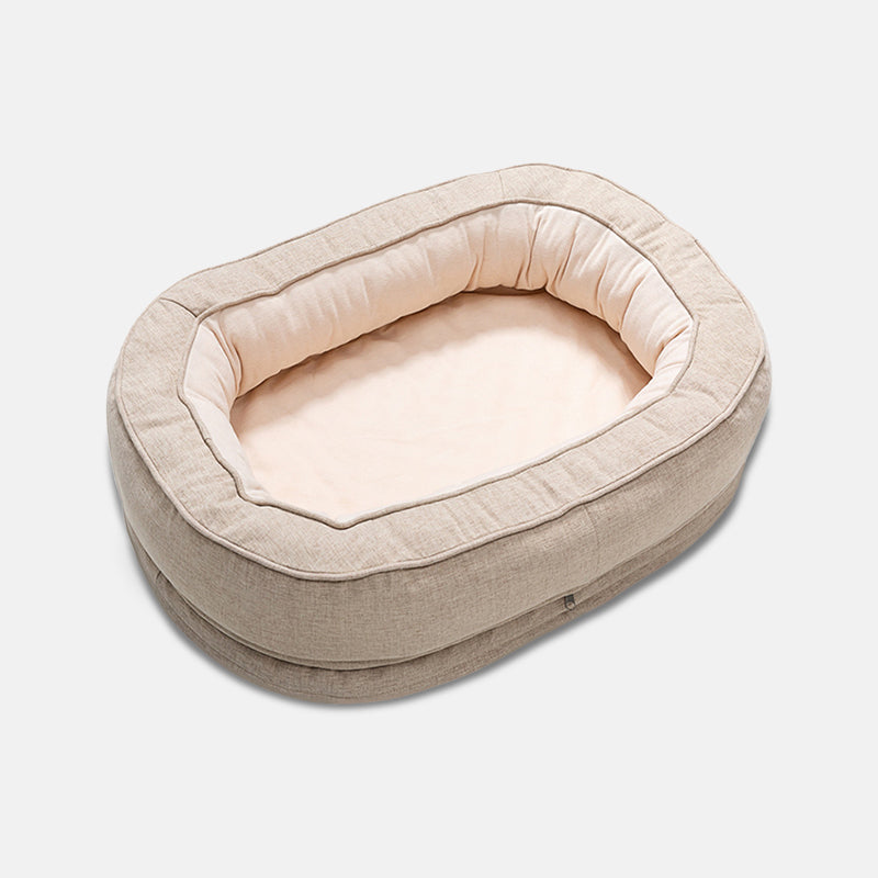 Beiges ovales Hundebett aus Leinen, gemütlich und weich, ideal für kleine Hunde.