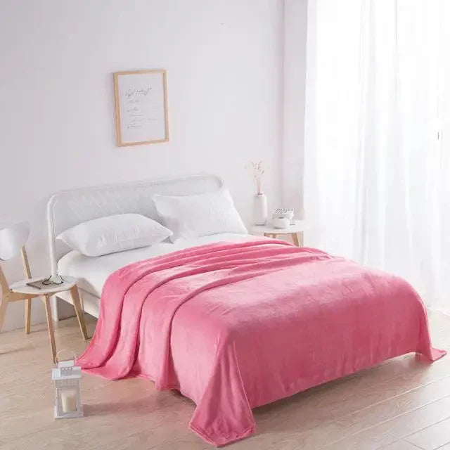 Rosa Fleecedecke auf weißem Bett in hellem Schlafzimmer, gemütliche Wohnkultur, modernes Design.