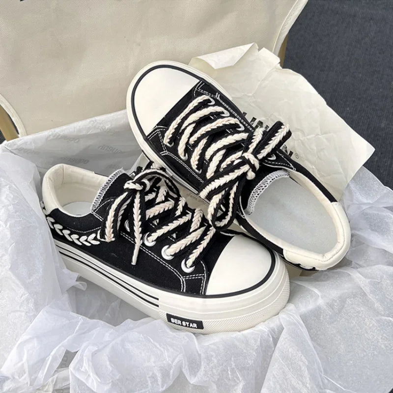 Schwarze Canvas-Sneaker mit weißen Schnürsenkeln und Blattmuster, Unisex, modisch, bequem.