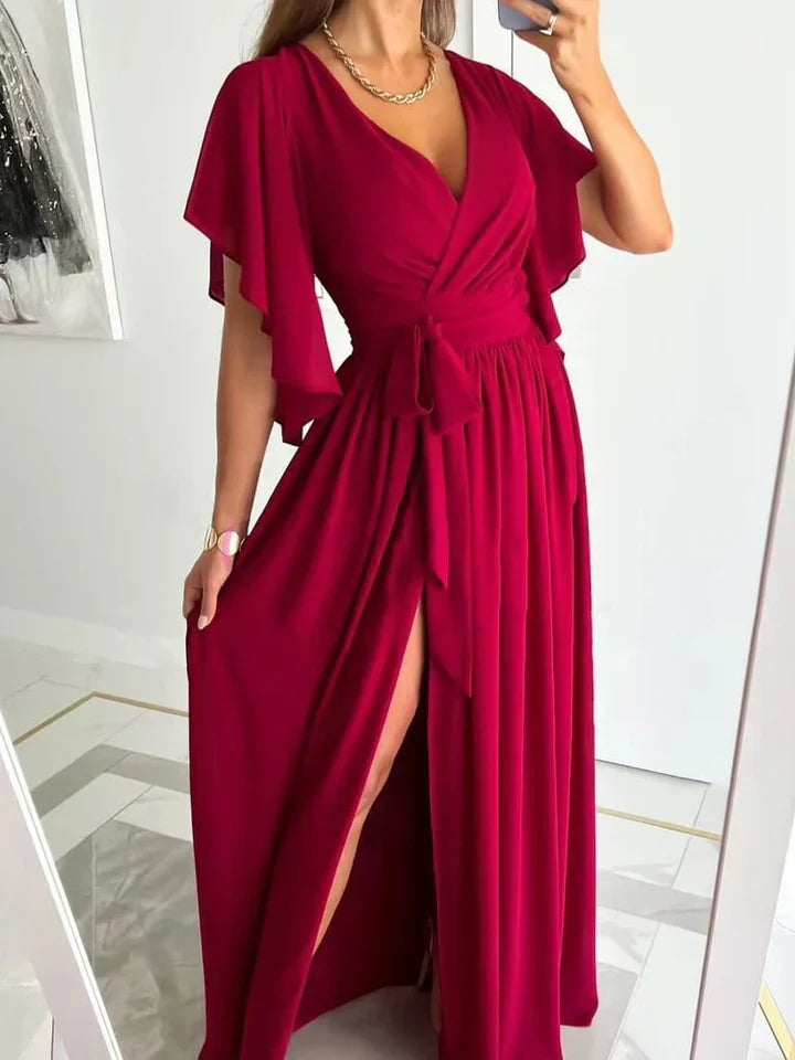 Frau in elegantem, rotem Maxikleid mit V-Ausschnitt und Schlitz, ideal für Abendveranstaltungen.