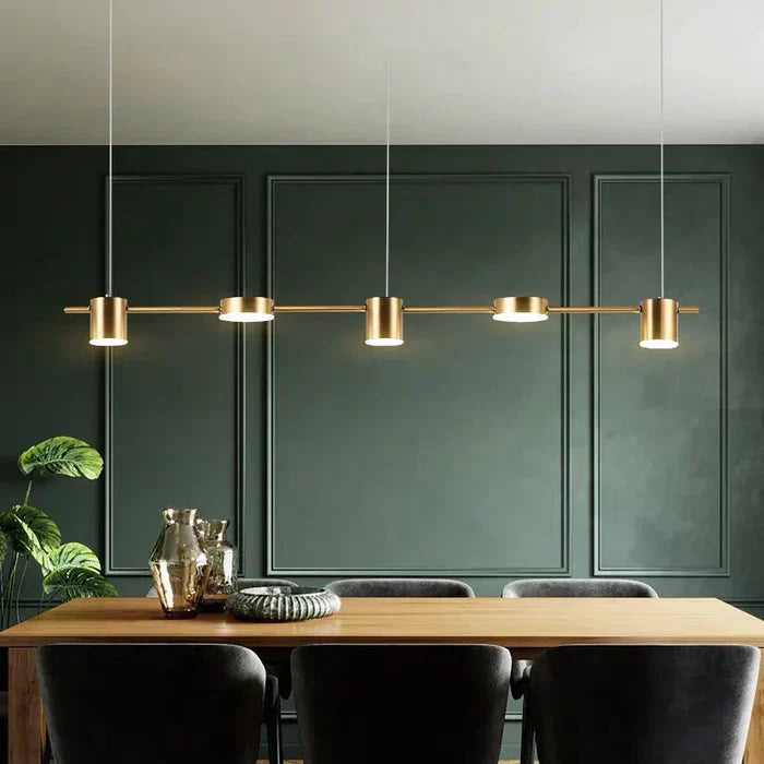Goldene Pendelleuchte über Esstisch, modernes Design, Wohnzimmerbeleuchtung, minimalistisch.