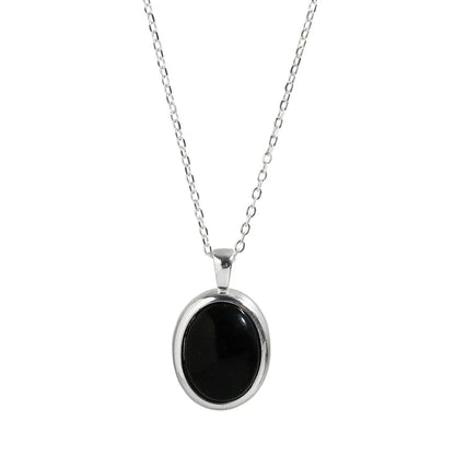 Silberkette mit ovalem schwarzem Anhänger, eleganter Schmuck, Damenaccessoire.