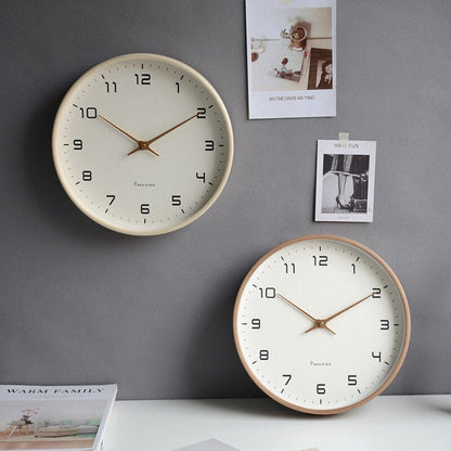 Zwei beige Wanduhren mit arabischen Ziffern auf grauer Wand, modernes minimalistisches Design.