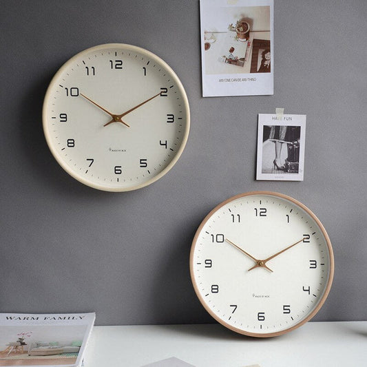 Zwei beige Wanduhren mit arabischen Ziffern auf grauer Wand, modernes minimalistisches Design.
