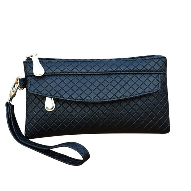 Schwarze Damenhandtasche mit Rautenmuster, Reißverschluss und Trageriemen aus Lederimitat.
