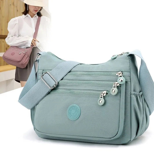 Hellblaue Umhängetasche mit Reißverschlüssen, verstellbarem Gurt, Damenmode Accessoire.