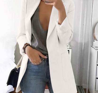 Frau in weißem Blazer, grauem Top und Jeans, modisch, elegant, Freizeitkleidung, Innenraum.
