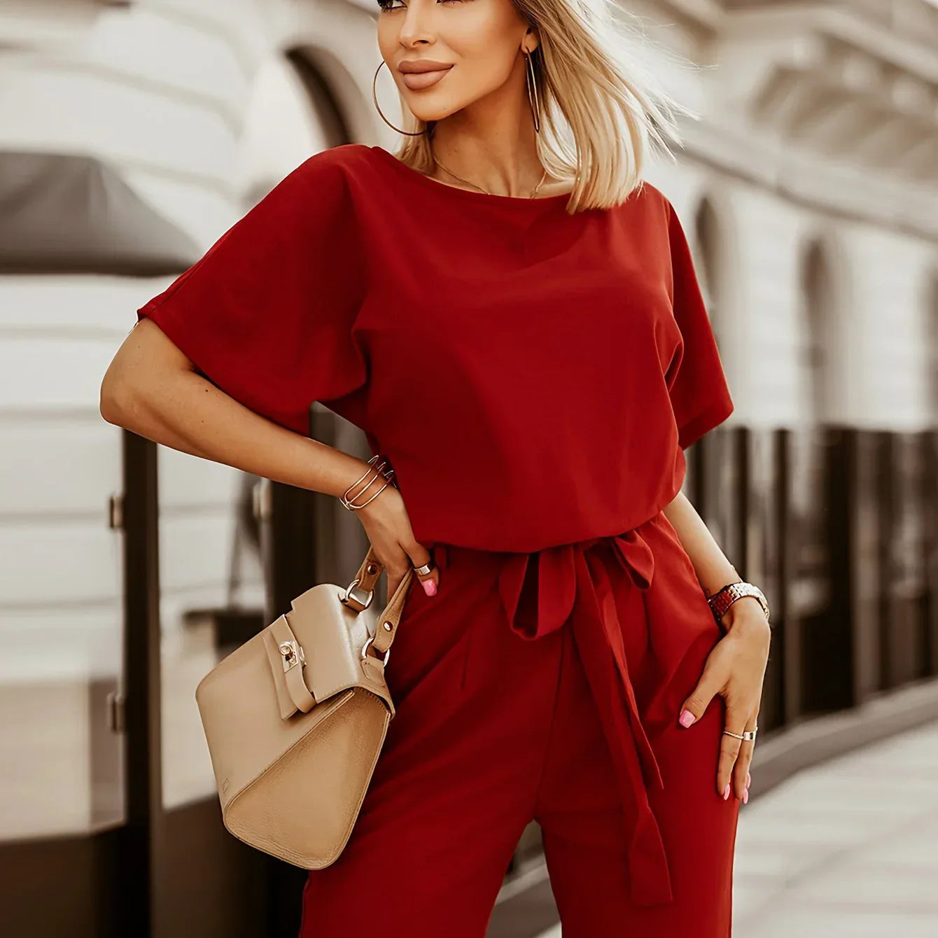 Frau in rotem Jumpsuit mit beiger Tasche, modisch, elegant, Stadt, Sommermode.