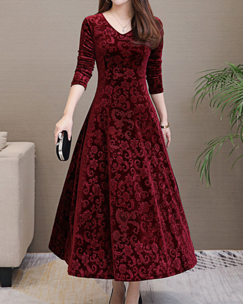 Frau in elegantem, langem, rotem Samtkleid mit Muster, hält schwarze Clutch, Abendmode.