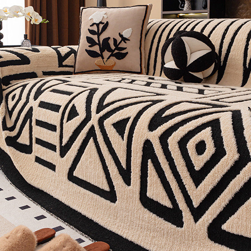 Soffa med beige överdrag och svart geometriskt mönster av trianglar och romber, med blomkudde 17