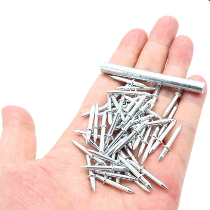 Handfull av små dubbelspetsade metallspikar med en sexkantig hylsa liggande på en utsträckt handflata, som visar storleken. 1