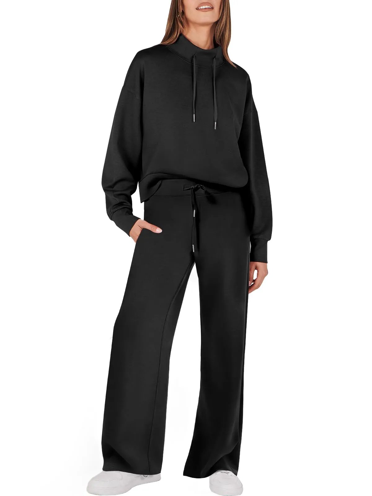 Frau in schwarzem Damen-Zweiteiler, Kapuzenpullover und Hose, lässige Mode, bequemes Outfit.