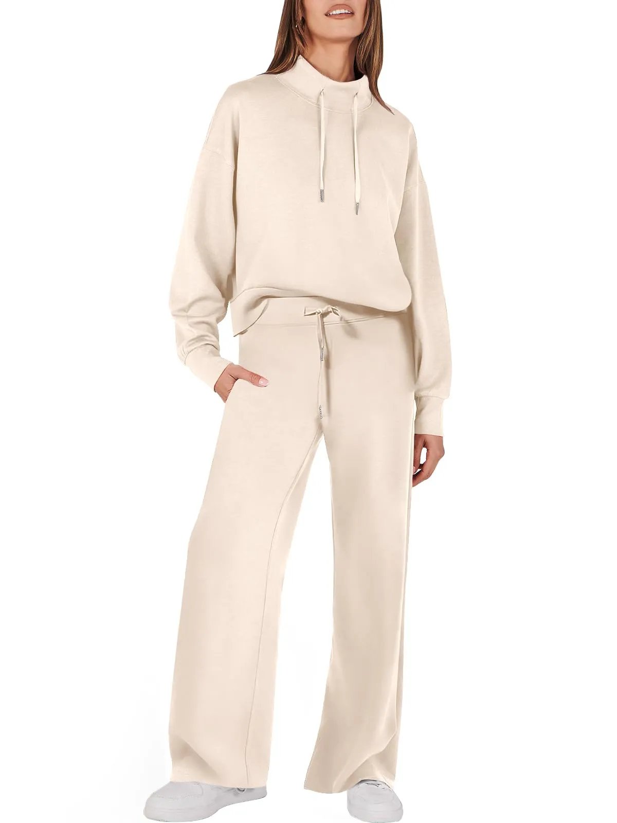 Frau in cremefarbenem Damenanzug, Kapuzenpullover und Hose, Freizeitmode, bequemes Outfit.
