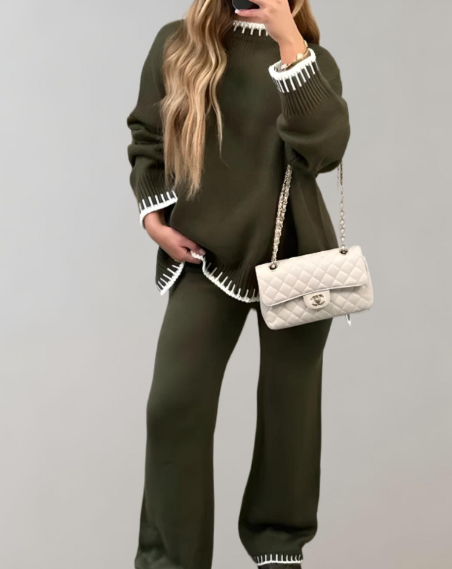 Frau in olivgrünem Zweiteiler, Strick, mit weißer Handtasche, modisch, elegant, nachhaltig.