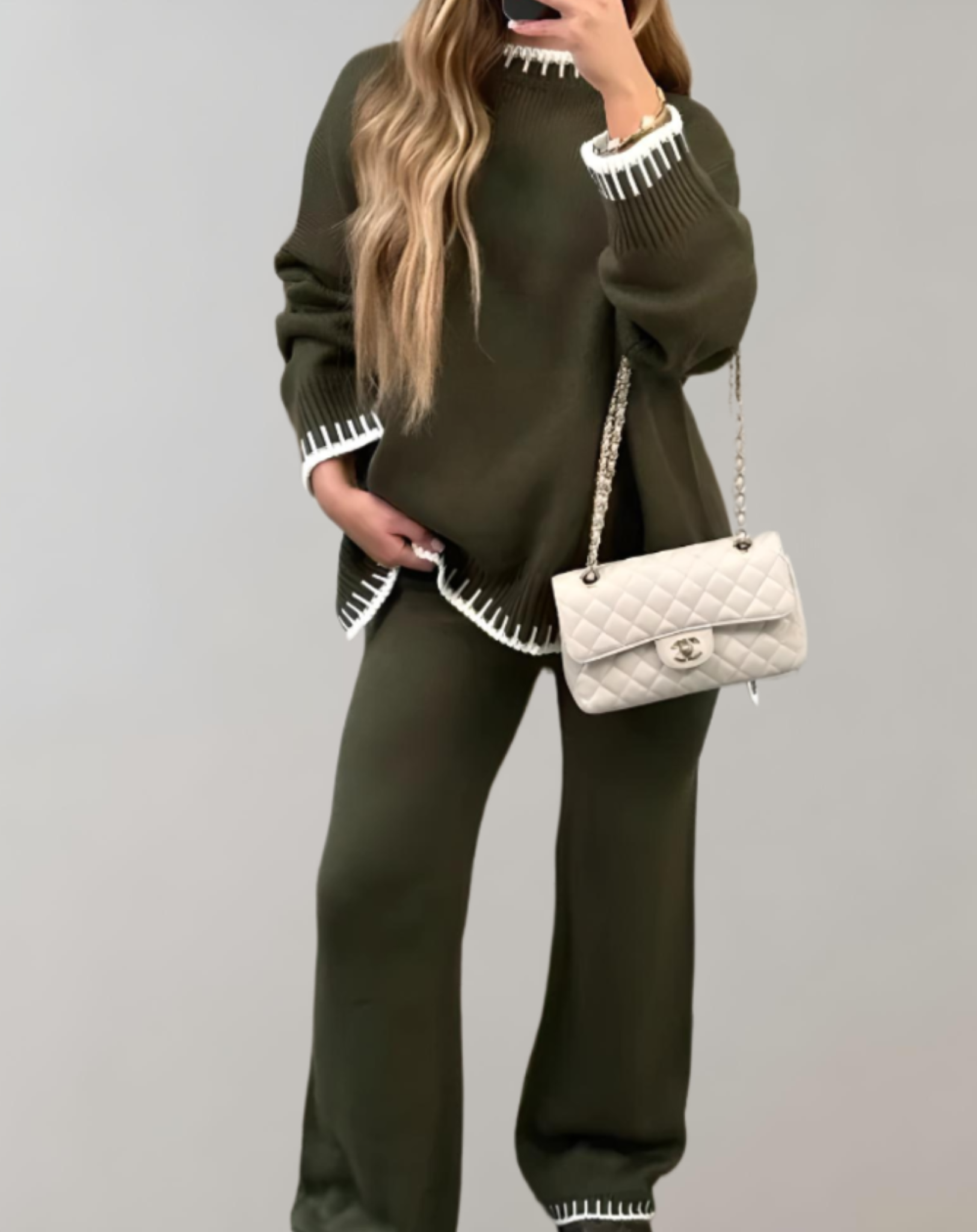 Frau in olivgrünem Zweiteiler, Strick, mit weißer Handtasche, modisch, elegant, nachhaltig.