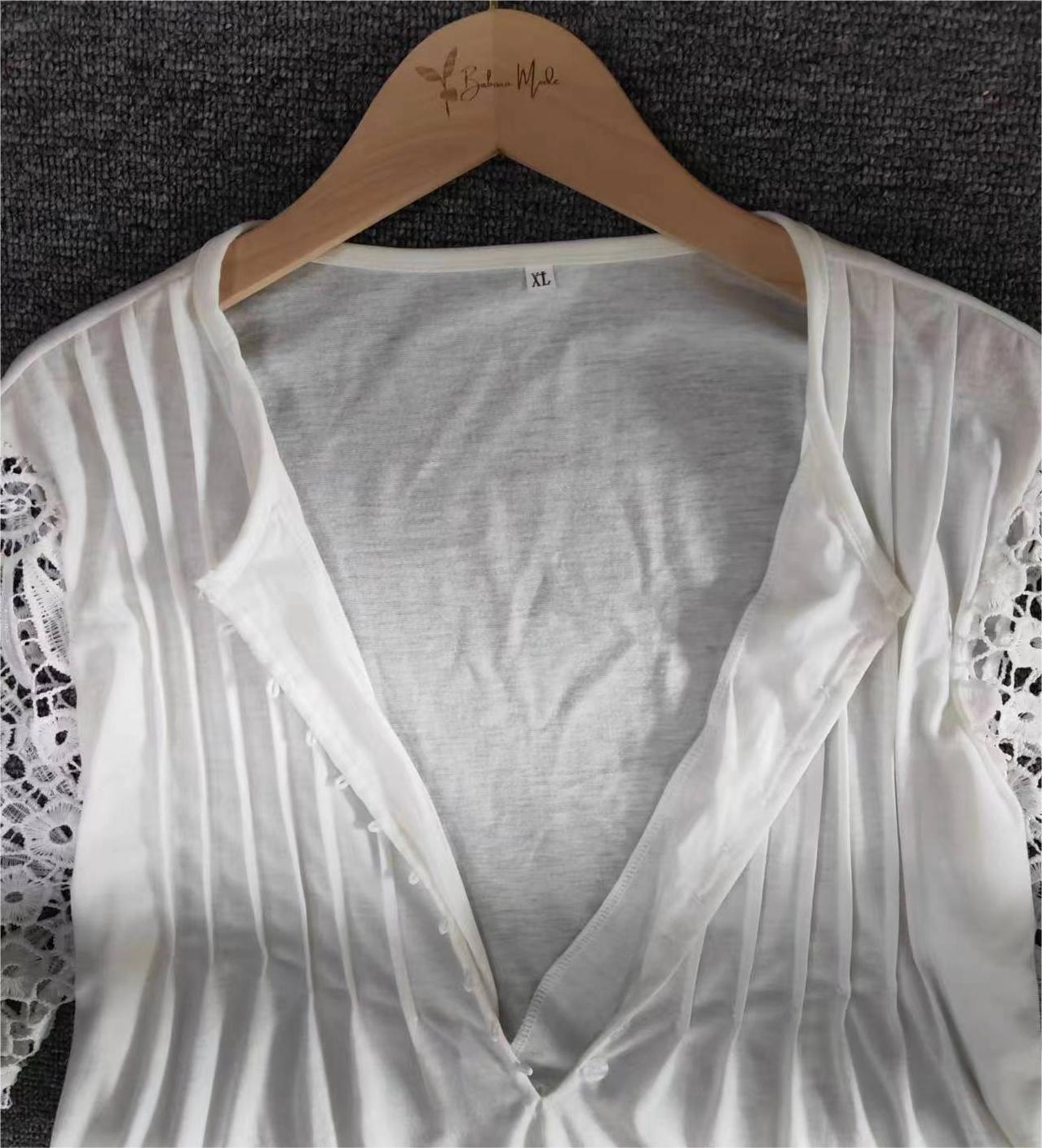 Weiße Damenbluse mit Spitzenärmeln, Faltenmuster, Holzkleiderbügel, Größe XL.