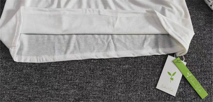 Weiße Bio-Baumwoll-T-Shirt, nachhaltige Mode, Etikett, umweltfreundlich, auf grauem Hintergrund.