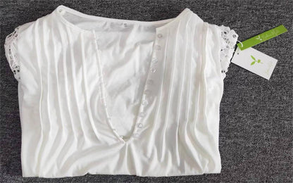 Weiße Damenbluse mit Spitzenärmeln, Knopfleiste, aus Baumwolle, auf grauem Hintergrund.