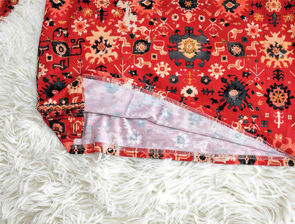 Roter Boho-Teppich mit ethnischem Muster auf weißem, flauschigem Teppichboden.