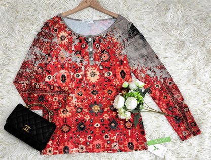 Rotes Damenoberteil mit orientalischem Muster, Blumen, schwarzer Tasche, auf weißem Teppich.
