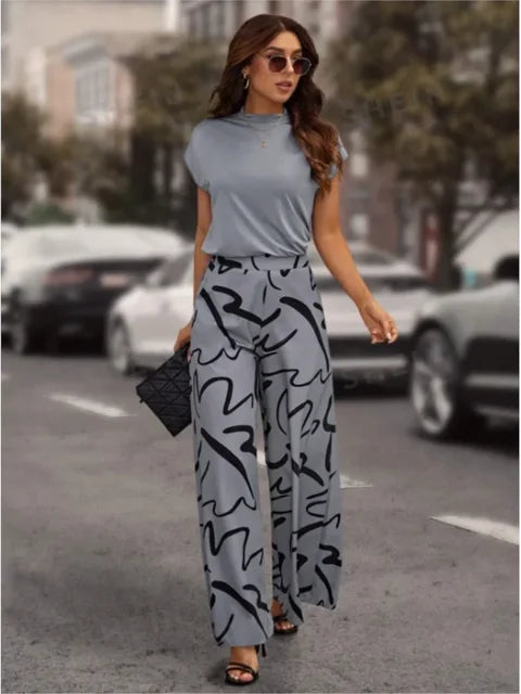 Frau in grauer, weit geschnittener Hose mit abstraktem Muster, lässiges Frühlings-Sommer-Outfit.