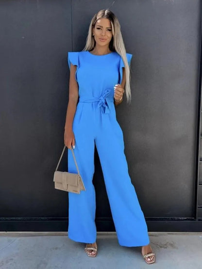 Frau in blauem Jumpsuit mit Schmetterlingsärmeln, breitem Bein, eleganter Streetwear, Sommermode.