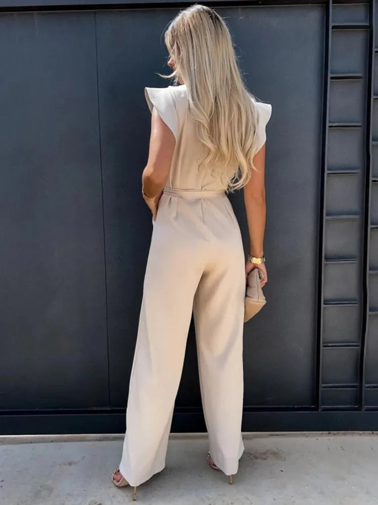 Frau in elegantem, beigem Jumpsuit mit Schmetterlingsärmeln und weitem Bein, Sommermode 2024.