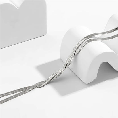 Silberne Schlangenkette auf weißem Hintergrund, elegantes Schmuckdesign, minimalistisch.
