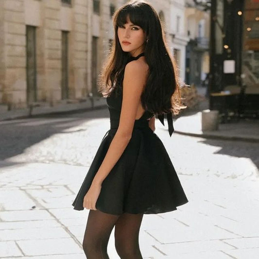 Frau in schwarzem Kleid auf Straße, modisch, elegant, Stadt, Tageslicht, lange Haare.