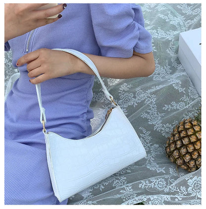 Frau in lila Kleid mit weißer Lederhandtasche auf Spitzenstoff, Ananas daneben.