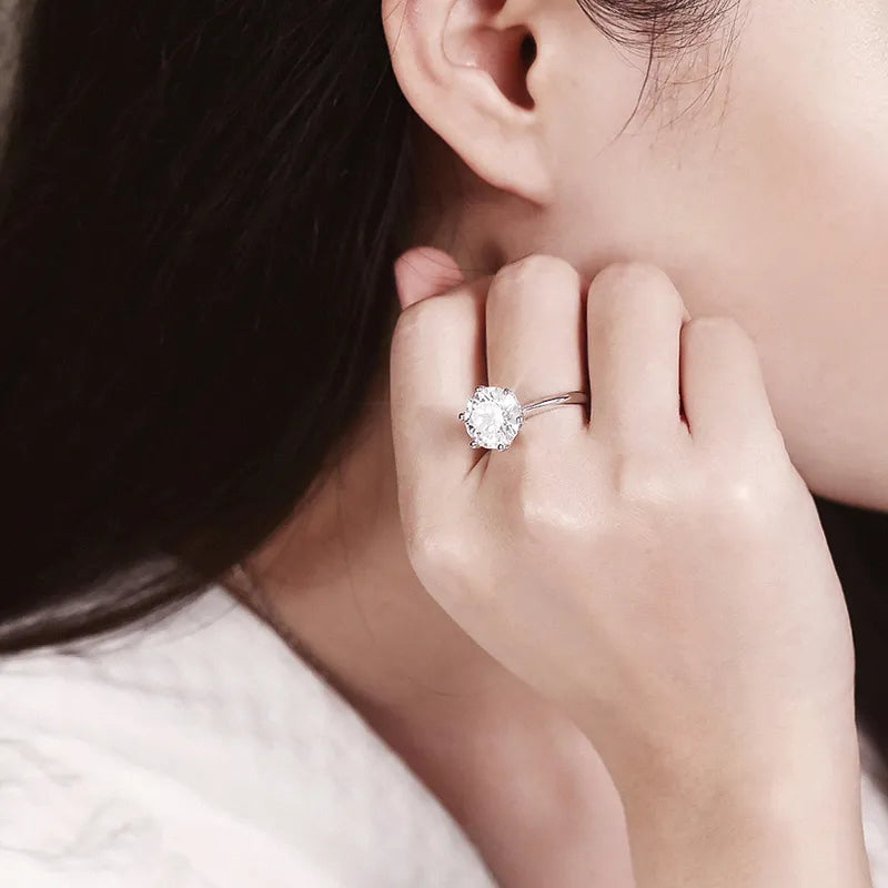 Frau mit elegantem Verlobungsring, großer Diamant, Silberband, Nahaufnahme, stilvoll.