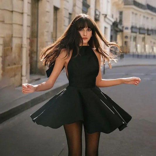Frau in schwarzem Cocktailkleid auf Straße, elegantes Abendoutfit, Modefotografie.
