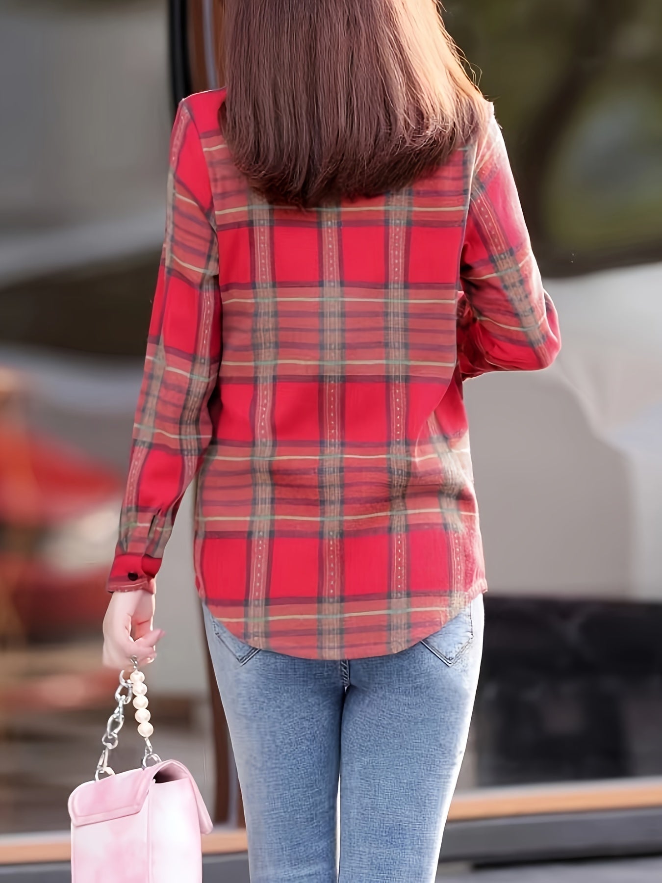 Frau in rotem Karohemd und blauer Jeans mit rosa Handtasche, Rückansicht.