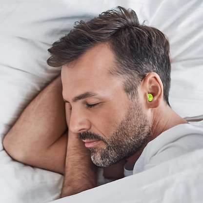 Mann schläft mit grünen Ohrstöpseln im Bett, Lärmschutz, Schlafhilfe, Komfort.