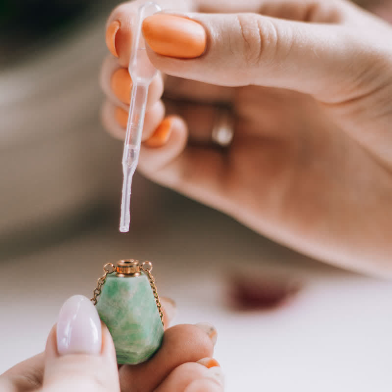 Frau mit Pipette und grünem Edelstein-Flakon, ätherisches Öl, Aromatherapie, Nahaufnahme.