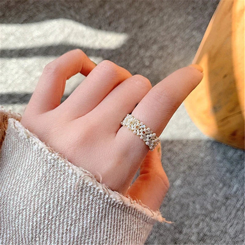 Damenring aus Silber mit filigranem Blumenmuster, eleganter Schmuck, modisches Accessoire.