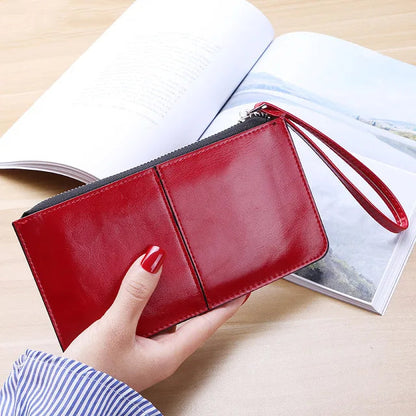 Rote Lederhandtasche mit Reißverschluss, Damenmode, elegantes Design, auf Holztisch.