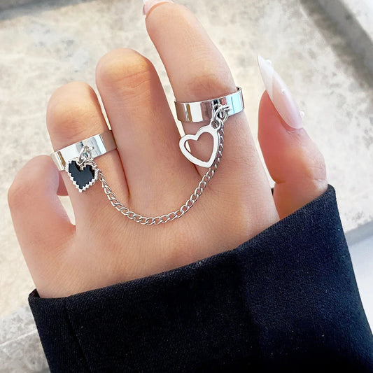 Silberne Doppelfinger-Ringe mit Herzanhänger und Kette, modisches Schmuckdesign.