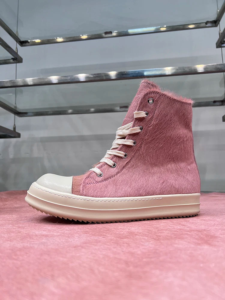 Rosa High-Top-Sneaker aus Leder mit weißer Sohle und Schnürsenkeln auf rosa Hintergrund.