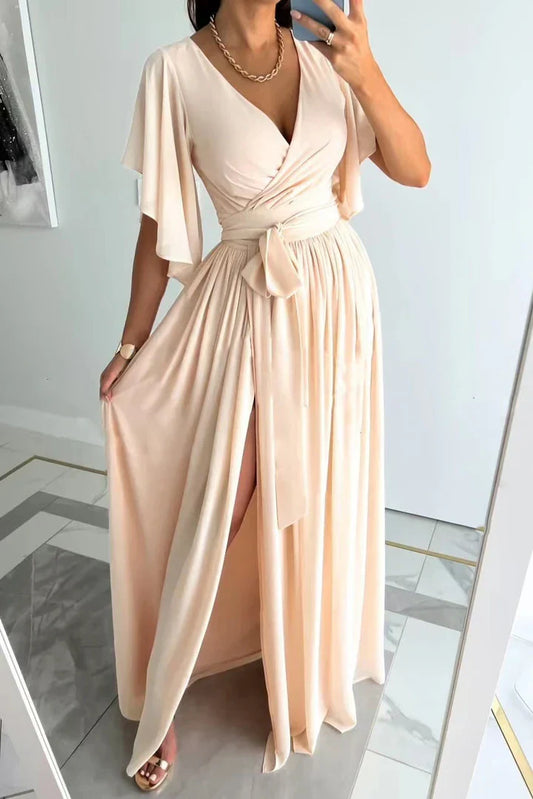 Frau in eleganter, cremefarbener Maxikleid mit V-Ausschnitt und Gürtel, Spiegel-Selfie.