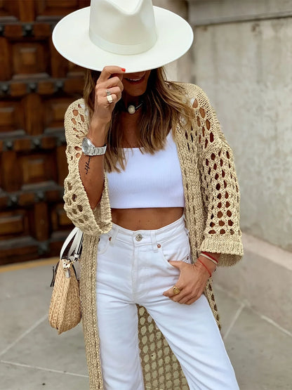 Frau mit weißem Hut, gehäkeltem Cardigan, weißem Top und Hose, modisch, Sommeroutfit.