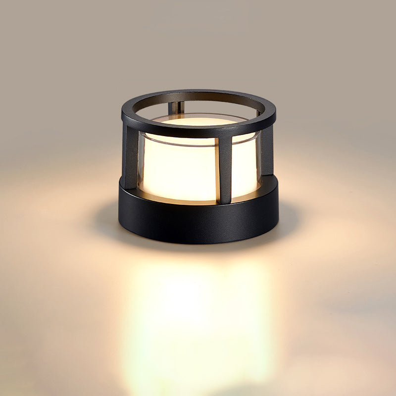 Rund svart lampa med öppen ringformad ram upptill och lysande vit skärm mot neutral bakgrund. 9