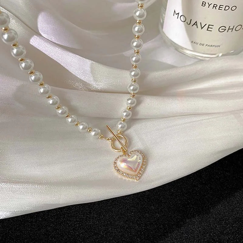 Perlenkette mit Herzanhänger auf Seide, eleganter Schmuck, luxuriöses Accessoire, Damenmode.