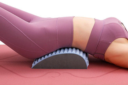 Frau in lila Sportkleidung auf Rückentrainer, Yoga-Matte, Fitness, Rückenstütze, Dehnung.