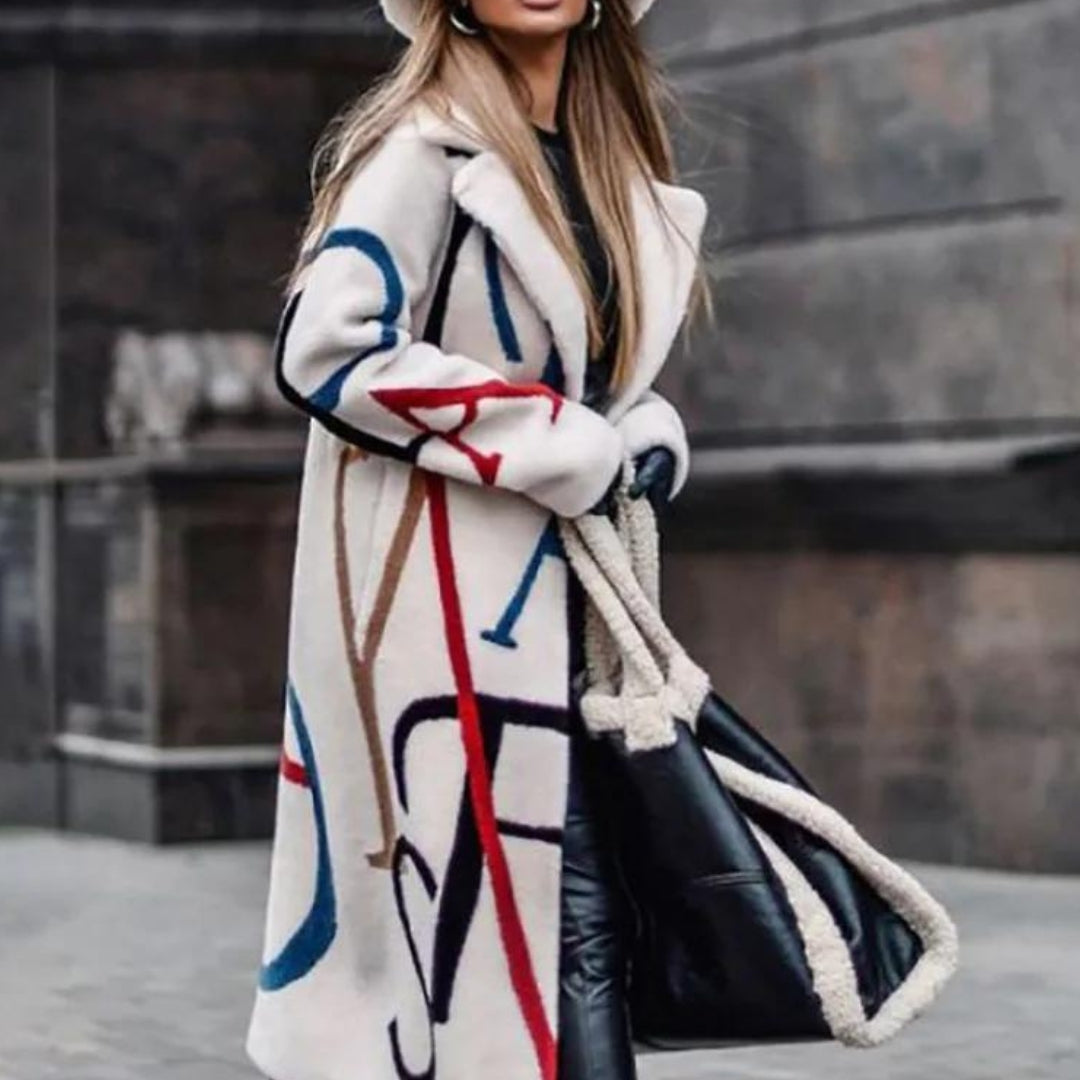 Frau in weißem Mantel mit buntem Muster, schwarze Lederhose, große schwarze Tasche, Wintermode.