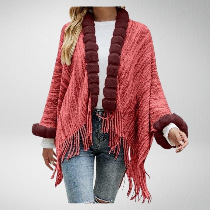 Frau trägt roten Poncho mit Fransen, Strickmuster, braune Akzente, lässiger Herbstlook.