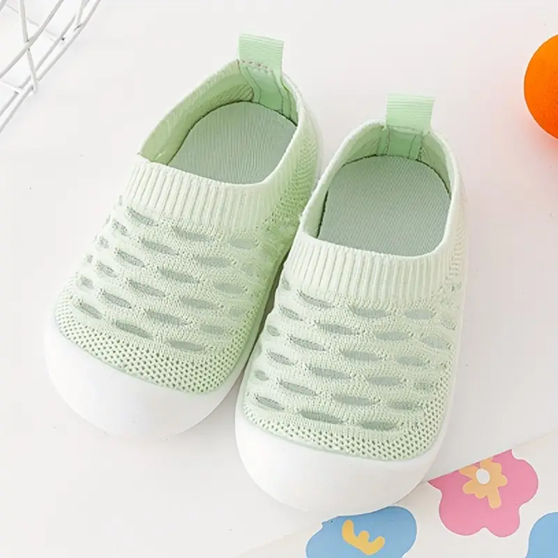 Grüne Baby-Sneaker aus Strickstoff mit weißer Sohle, rutschfest, atmungsaktiv.