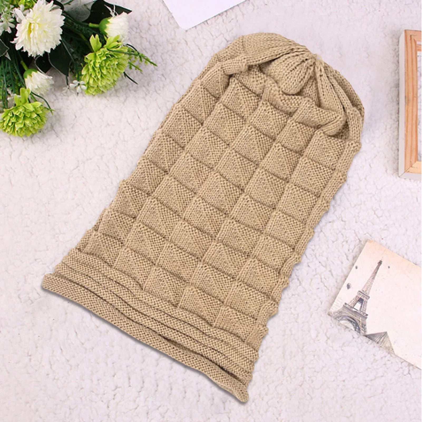 Beige gestrickter Schlafsack für Babys, weiches Material, quadratisches Muster, gemütlich.