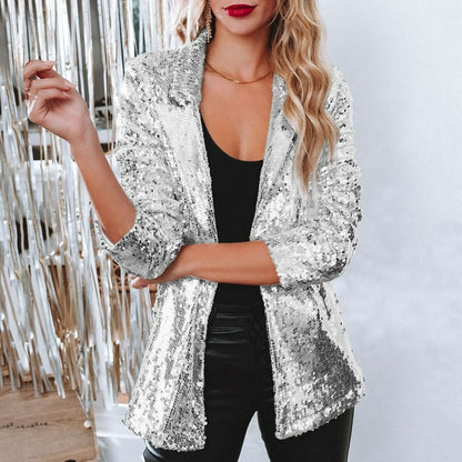Frau in silbernem Paillettenblazer, schwarzem Top und Lederhose, glamouröses Party-Outfit.