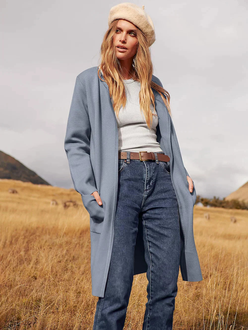 Frau in blauem Mantel und Jeans, beige Mütze, Herbstlandschaft, Mode, Outdoor, stilvoll.